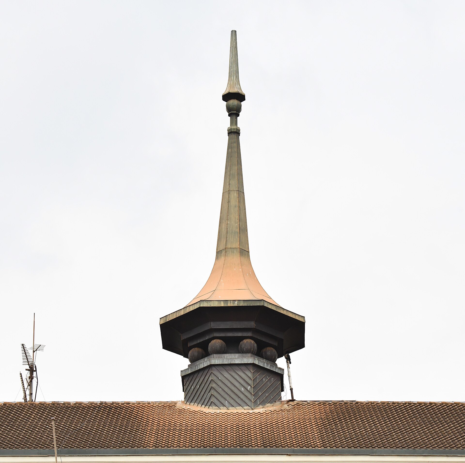 Detail of the metal spire and cupola on the roof of the Bulange building in Mengo, against a blue sky.